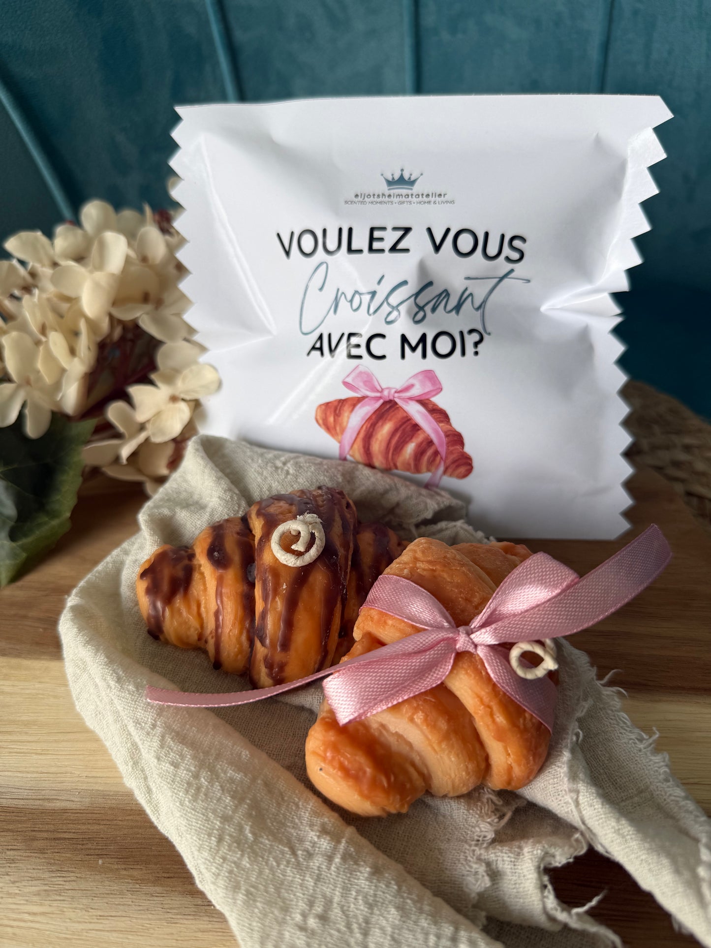 Detailreiche Croissant-Duftkerze in realistischer Gebäckoptik mit goldbrauner Oberfläche und geschichteten Butterteig-Details. Die handgegossene Kerze erinnert an ein frisch gebackenes französisches Croissant aus einer Patisserie und verströmt einen warmen, süßen Duft. Stilvoll dekoriert auf hellem Untergrund im minimalistischen Café- und Interior-Stil.