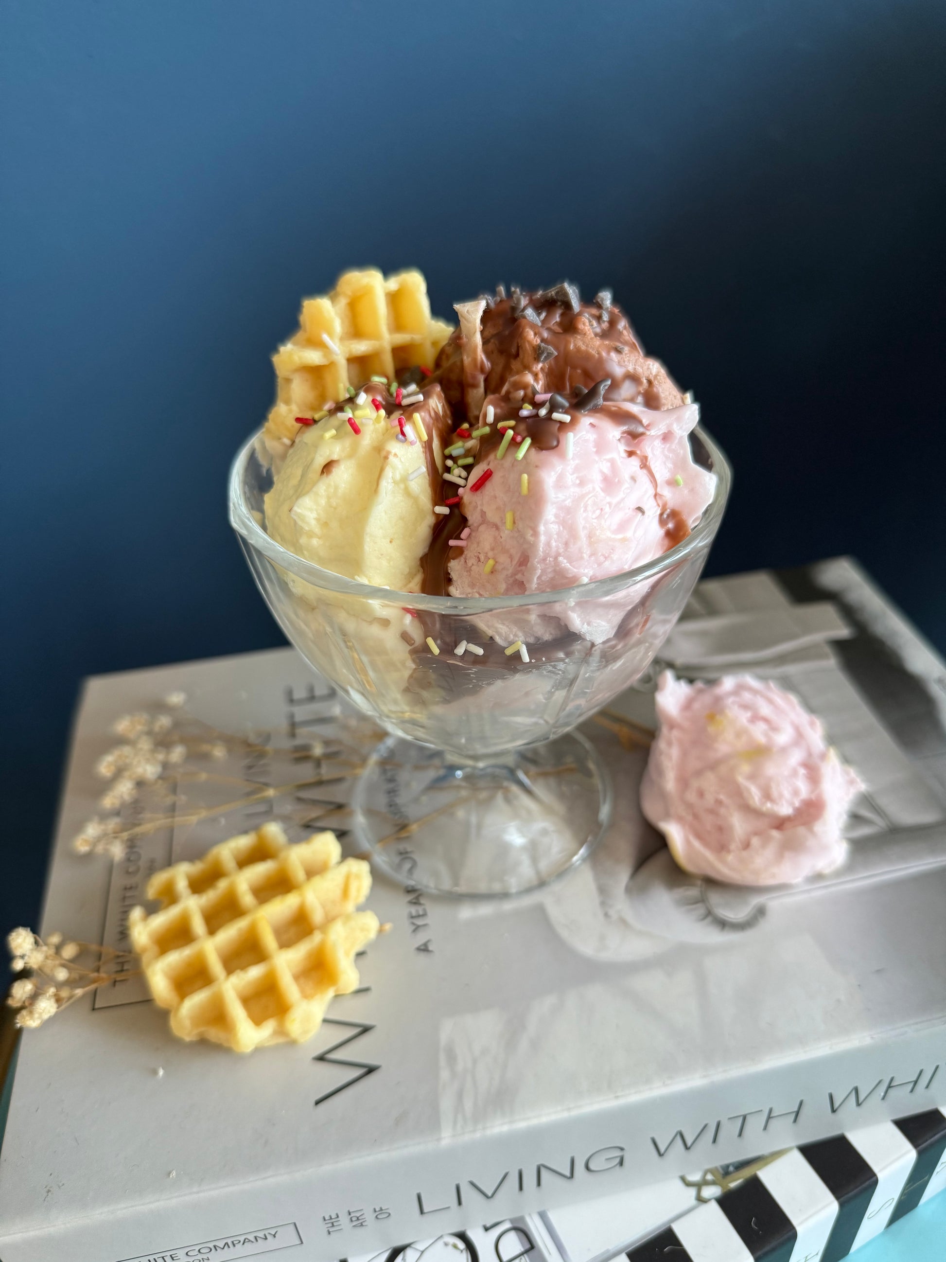 Duftkerze in Form von drei Eiskugeln mit bunten Streuseln und Waffel in einer Glasschale/ Eisbecher dekorativ arrangiert. Sojawachs