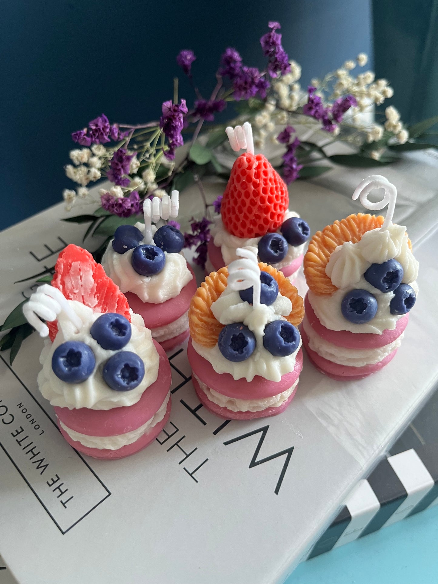 Verspielte Macaron-Duftkerze in realistischer Patisserie-Optik mit dekorativem Beeren-Topping aus Erdbeeren, Himbeeren und roten Früchten. Die handgegossene Kerze erinnert an ein luxuriöses französisches Dessert und überzeugt mit detailreicher Sahne- und Gebäckstruktur im süßen Café- und Boutique-Stil.