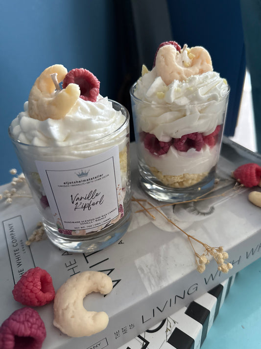 Zu sehen ist auf dem Bild eine Vanille Kipferl Duftkerze im Desserstil die nach Vanille Duftet. Täuschend echte Vanillekipferl als Topping oben drauf. Sojawachs.