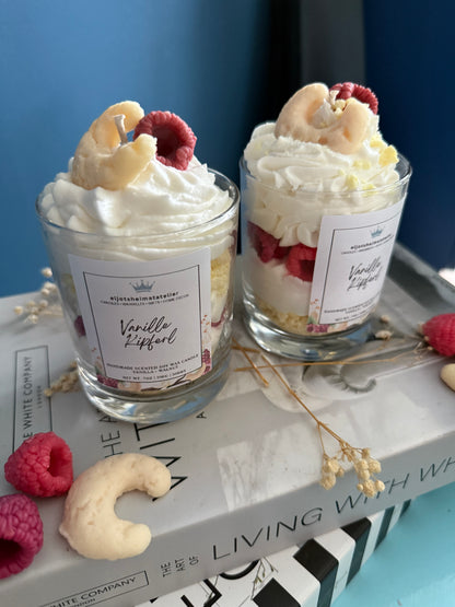 Zu sehen ist auf dem Bild eine Vanille Kipferl Duftkerze im Desserstil die nach Vanille Duftet. Täuschend echte Vanillekipferl als Topping oben drauf. Sojawachs.